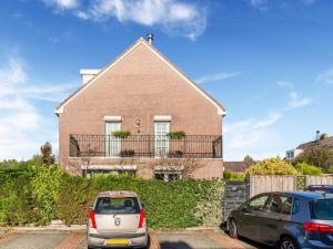 モニキンダムにあるModern Holiday Home in Monnickendam with Roofed Terraceのレンガ造りの家の前に停められた車2台