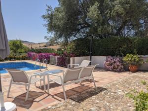 AlmogíaにあるLovely Holiday Home with Private Swimming Pool in Almog aのプールサイドのパティオ(テーブル、椅子付)