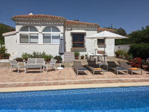 AlmogíaにあるLovely Holiday Home with Private Swimming Pool in Almog aのプール、パティオ(椅子、パラソル付)が備わる家です。
