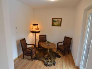 ein Wohnzimmer mit einem Tisch, Stühlen und einer Lampe in der Unterkunft Holiday Home in Filz near River in Filz