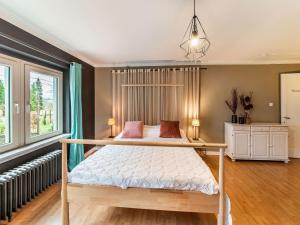 um quarto com uma cama com uma estrutura em madeira em Beautiful group house with large garden em Gouvy