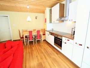 kuchnia z czerwoną kanapą i jadalnią w obiekcie Apartment in St Michael near Ski Slopes w mieście Sankt Michael im Lungau