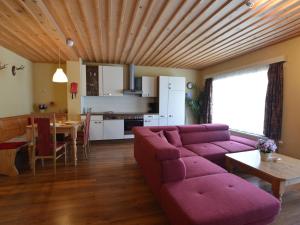 salon z fioletową kanapą i stołem w obiekcie Apartment in St Michael near Ski Slopes w mieście Sankt Michael im Lungau
