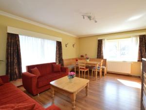 salon z czerwoną kanapą i stołem w obiekcie Apartment in St Michael near Ski Slopes w mieście Sankt Michael im Lungau