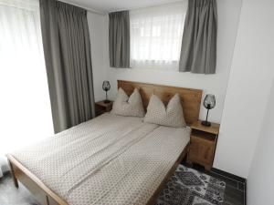 een slaapkamer met een bed met witte lakens en kussens bij Apartment in Untertauern near ski area in Untertauern