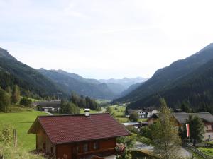 een klein huis in een vallei met bergen op de achtergrond bij Apartment in Untertauern near ski area in Untertauern