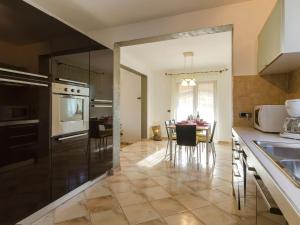a kitchen with black appliances and a table with chairs at Comfortable Holiday Home in Rovinj with Private Pool in Rovinjsko Selo