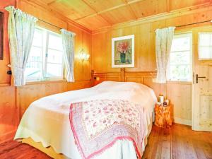 um quarto com uma cama e duas janelas em Quaint holiday home with fireplace and terrace em Pähl