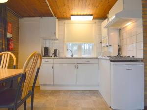 StramproyにあるAdmirable Holiday Home in Stramproy with Gardenの白いキャビネット、シンク、テーブル付きのキッチンが備わります。