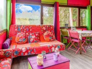 a living room with a red couch and a table at Lively Holiday Home with Garden Barbecue Garden Furniture in Houffalize