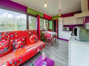 a living room with a red couch and a kitchen at Lively Holiday Home with Garden Barbecue Garden Furniture in Houffalize