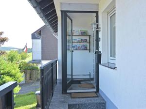 un ingresso a una casa con una porta su un portico di Holiday home in Winterberg Gr nebach with terrace a Winterberg