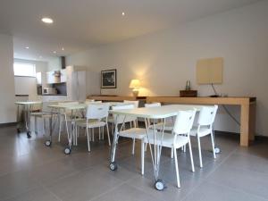 a dining room with white tables and white chairs at Modern Holiday Home in Flemish Ardennes with Bubble Bath in Zottegem