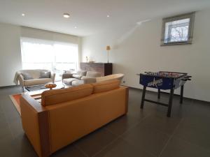 a living room with a couch and a table with a game at Modern Holiday Home in Flemish Ardennes with Bubble Bath in Zottegem