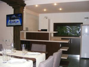 Traveland Boutique Resort Poiana Brasov في بويانا براسوف: غرفة طعام مع طاولة وتلفزيون