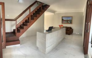 a living room with a staircase and a couch at Rio Claro Comfort Hostel e Suítes in São Luís