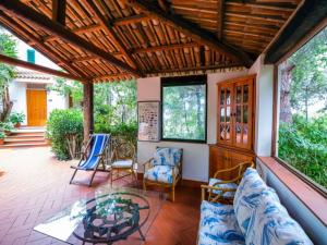 a screened in porch with chairs and a table at Spacious Villa in Calabria with Swimming Pool in Ricadi