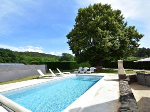 uma piscina com espreguiçadeiras e uma árvore em Cozy Holiday Home in Saint L on sur em Sergeac