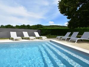 a group of lounge chairs and a swimming pool at Cozy Holiday Home in Saint L on sur in Sergeac