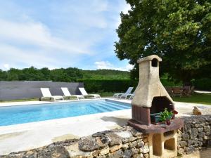 a pool with a stone wall next to a swimming pool at Cozy Holiday Home in Saint L on sur in Sergeac