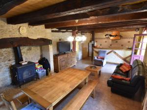 uma sala de estar com uma mesa de madeira e um fogão a lenha em Cozy Holiday Home in Saint L on sur em Sergeac