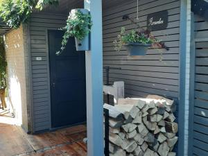 a blue door on a house with a pile of logs at Cottage in Durbuy with Terrace Garden Barbecue in Durbuy