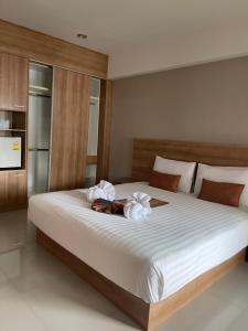 a bedroom with a large bed with white sheets at Unity Hotel in Si Sa Ket