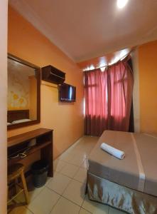 a bedroom with a bed and a mirror and a desk at Highway Budget Hotel in Ipoh