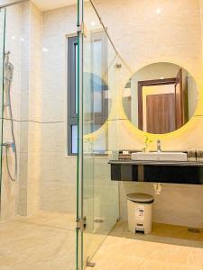 La salle de bains est pourvue d'une douche, d'un lavabo et d'un miroir. dans l'établissement Crown Dalat Hotel, à Đà Lạt