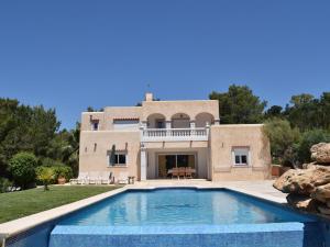 a villa with a swimming pool in front of a house at Belvilla by OYO Can Cova in Sant Josep