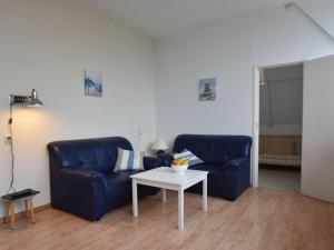 een woonkamer met een blauwe bank en een tafel bij Apartment with stunning views in Bergen aan Zee