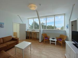 een woonkamer met een bank en een tafel bij Apartment with stunning views in Bergen aan Zee