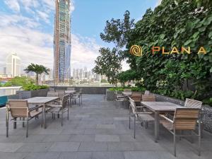 a patio with tables and chairs and a building at Opus LIV Signature in Kuala Lumpur