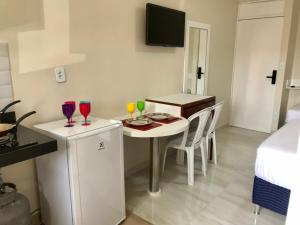 a small room with a table and chairs with wine glasses on it at Apartamento à beira mar da praia do francês in Praia do Frances
