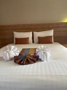 Una cama con dos toallas encima. en Unity Hotel, en Sisaket