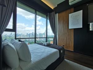 a bedroom with a bed with a large window at Opus LIV Signature in Kuala Lumpur