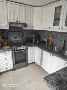 a kitchen with white cabinets and a stove top oven at Casa completa SAME Casa Blanca in Same