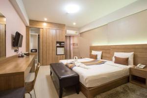 um quarto de hotel com uma cama e uma secretária em Unity Hotel em Si Sa Ket