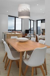 a dining room with a wooden table and white chairs at St Falls Resort in Falls Creek