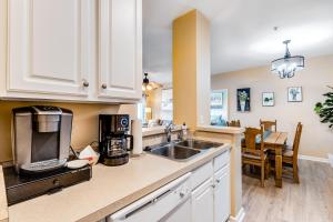 a kitchen with white cabinets and a sink at Villas at Bay Crossing - 34670 Villa Circle Unit #2304 in Lewes