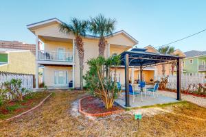 a house with a gazebo and palm trees at Smiles N Waves in Panama City Beach