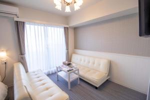 ein Wohnzimmer mit einem Sofa und einem Tisch in der Unterkunft Framboise KYOTO Hotel de charme in Kyoto