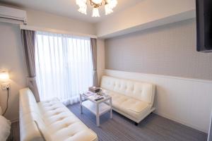 a living room with a couch and a table at Framboise KYOTO Hotel de charme in Kyoto