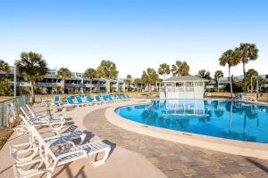 a swimming pool with lounge chairs and a resort at Sunnyside Beach & Tennis #54 in Panama City Beach