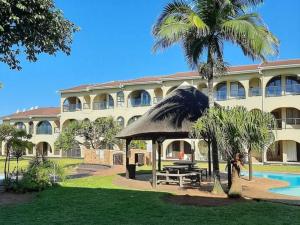 a large building with a table and a gazebo at Cabanas del Mar in Amanzimtoti