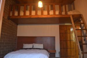 een slaapkamer met een stapelbed en een ladder naar een bed bij hermosa cabaña el rio in Zacatlán