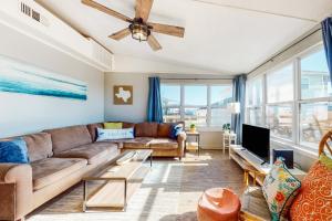 a living room with a couch and a tv at Sea It All in Freeport