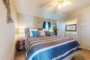 a bedroom with a bed and a ceiling fan at Sea It All in Freeport