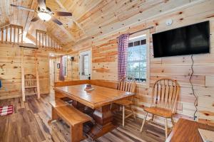 a dining room with a wooden table and a flat screen tv at Meandering Moose Cabin in Florissant