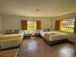 - une chambre avec 2 lits et 2 fenêtres dans l'établissement Palmar de Jericó Suites, à Jericó